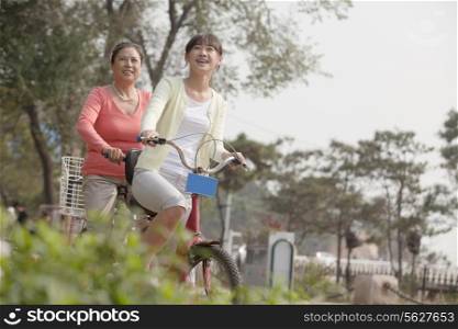 Grandmother and granddaughter riding tandem bicycle, Beijing