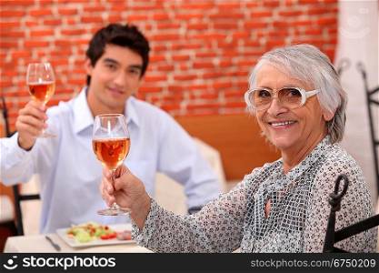 Grandmother and grandson having meal in restaurant