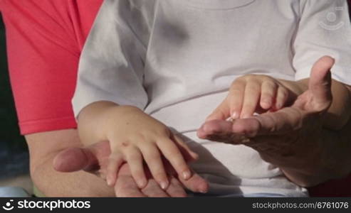 Grandmother and grandson holding hands close-up