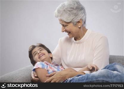 Grandmother and grandson playing on sofa