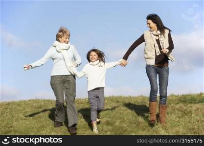 Grandmother And Mother Holding Hands With Young Girl
