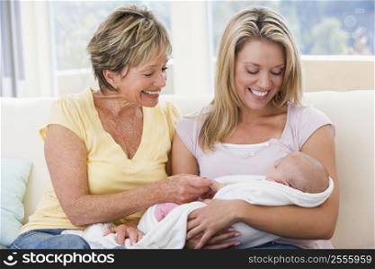 Grandmother and mother in living room with baby smiling
