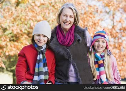 Grandmother and two children outdoors in park smiling (selective focus)