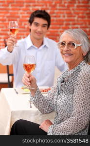 Grandmother and young man drinking rose wine