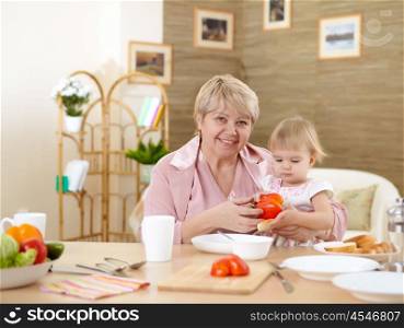 grandmother feeding her little baby granddaughter at home