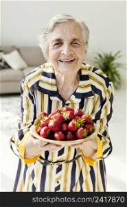grandmother holding fresh strawberries