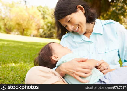 Grandmother Holding Sleeping Grandson In Park