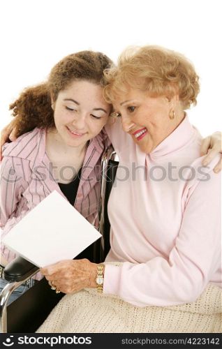 Grandmother in wheelchair reading a mother&rsquo;s day (or get well) card from her granddaughter. White background.