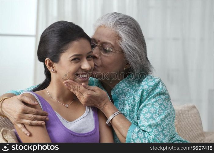 Grandmother kissing her granddaughter