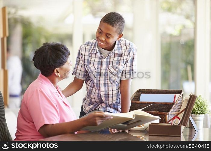 Grandmother Looking At Photo Album With Grandson