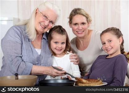 grandmother making crepes surrounded by daughter and grandchildren