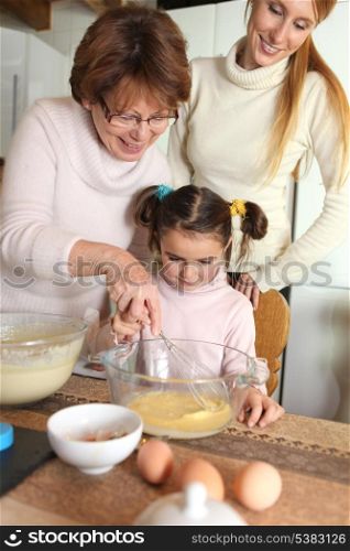 grandmother making crepes with little granddaughter