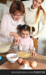grandmother making crepes with little granddaughter
