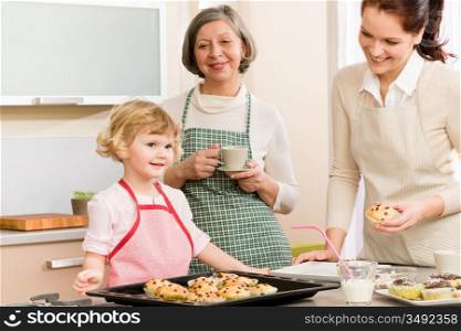 Grandmother, mother and child girl making cupcakes in kitchen