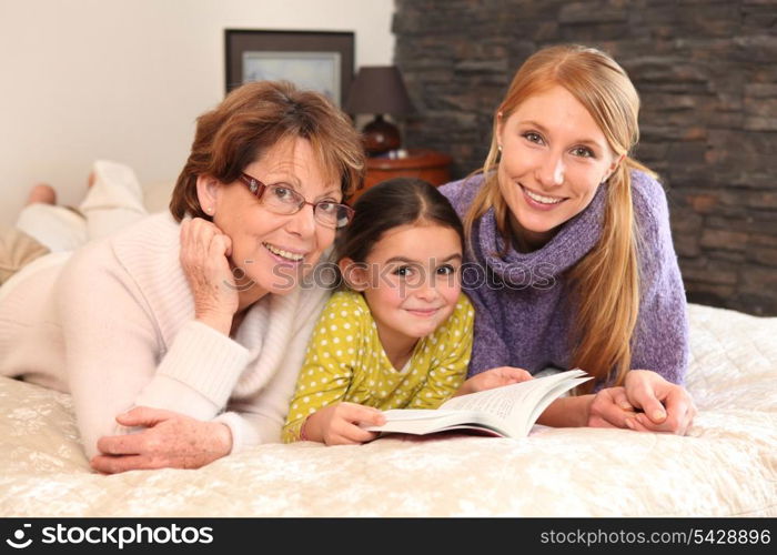 Grandmother, mother, and daughter lying on a bed