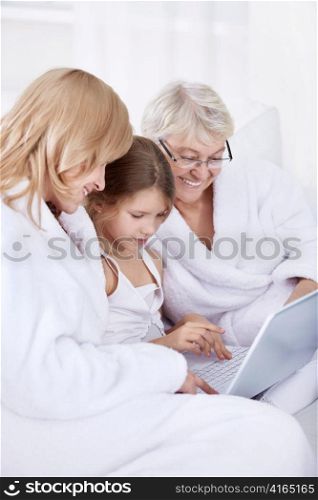 Grandmother, mother and daughter with laptop