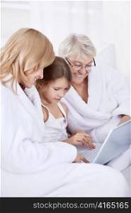 Grandmother, mother and daughter with laptop