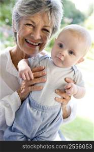 Grandmother outdoors on patio with baby smiling