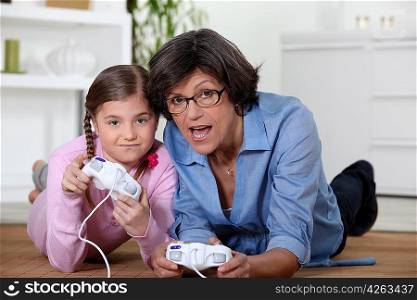 Grandmother playing a video game with her granddaughter