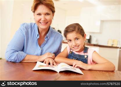 Grandmother Reading With Granddaughter At Home