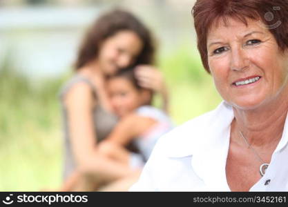Grandmother stood with daughter and grandson in background