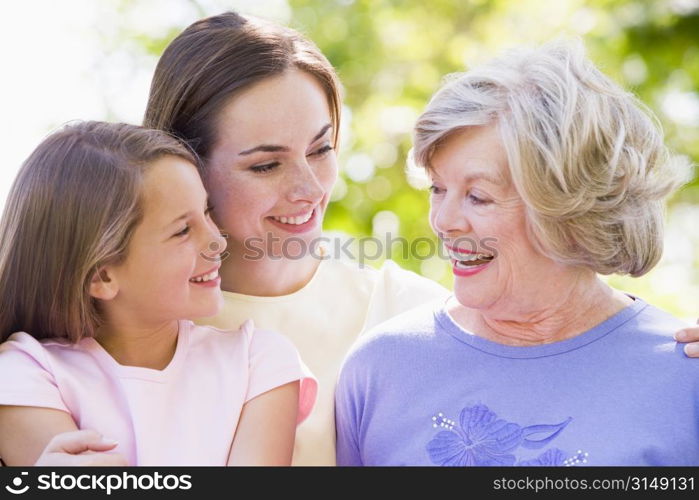 Grandmother with adult daughter and grandchild in park