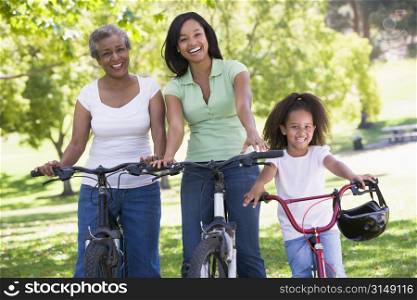 Grandmother with adult daughter and grandchild riding bikes