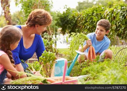 Grandmother With Grandchildren Working On Allotment