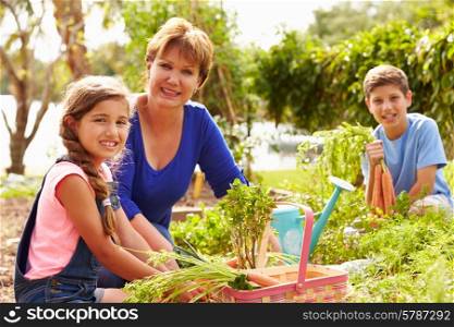Grandmother With Grandchildren Working On Allotment