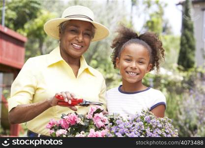 Grandmother With Granddaughter Gardening Together