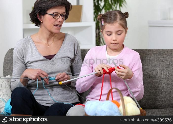 Grandmother with granddaughter knitting