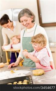 Grandmother with little girl prepare dough for baking in kitchen