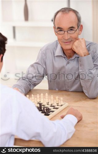 grandpa playing chess game with grandson