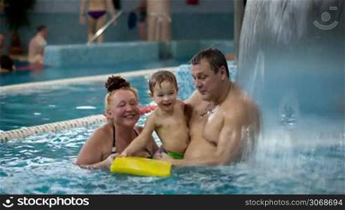 Grandparents and a grandson having fun together in the swimming pool