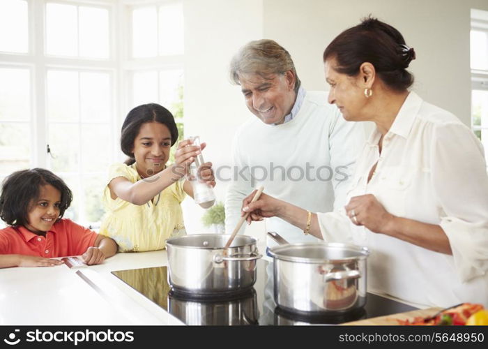 Grandparents And Grandchildren Cooking Meal At Home