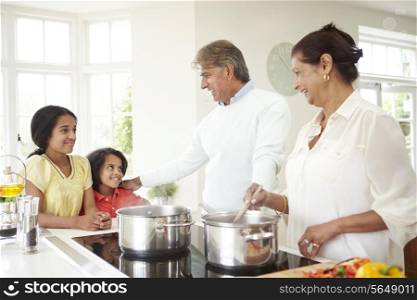 Grandparents And Grandchildren Cooking Meal At Home