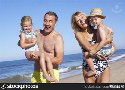Grandparents And Grandchildren Enjoying Beach Holiday