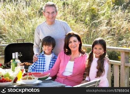 Grandparents And Grandchildren Having Outdoor Barbeque