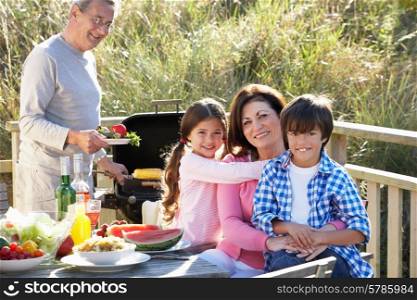 Grandparents And Grandchildren Having Outdoor Barbeque