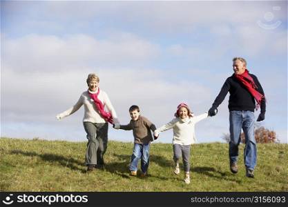 Grandparents And Grandchildren Running In The Park