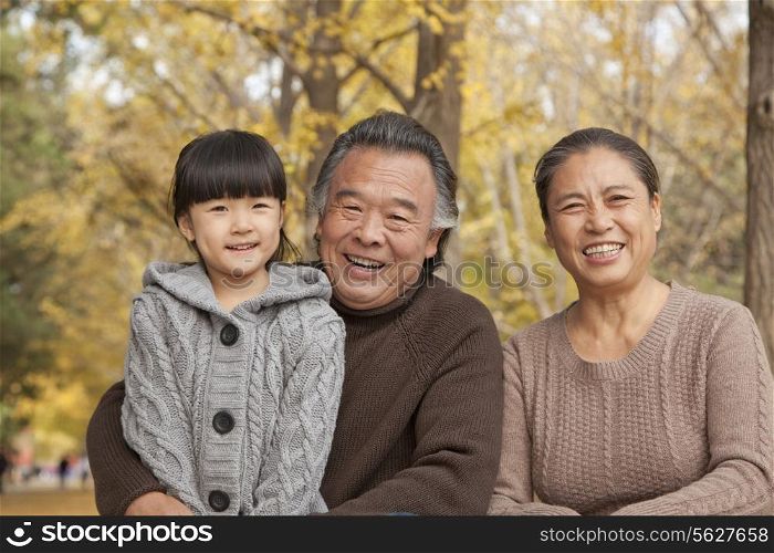Grandparents and granddaughter in park