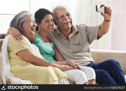 Grandparents and granddaughter taking a photograph of themselves