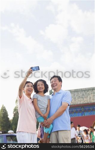 Grandparents and granddaughter taking self portrait with Cell Phone