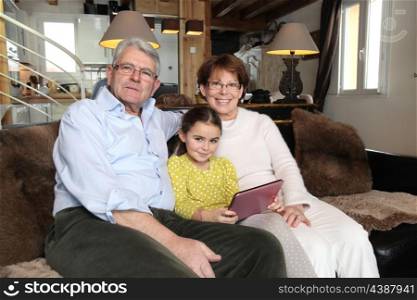 Grandparents and granddaughter using laptop computer