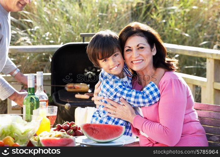 Grandparents And Grandson Having Outdoor Barbeque