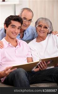 Grandparents and grandson looking through family album