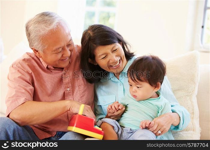 Grandparents And Grandson Playing With Toy Together