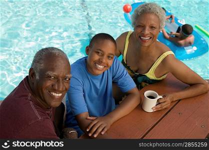 Grandparents and Grandson Sitting Poolside