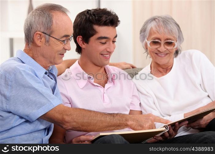 Grandparents and grandson watching photo album