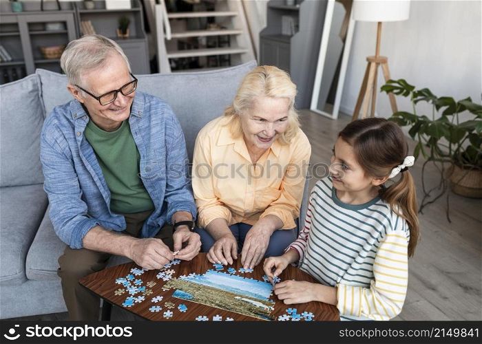 grandparents girl doing puzzle medium shot